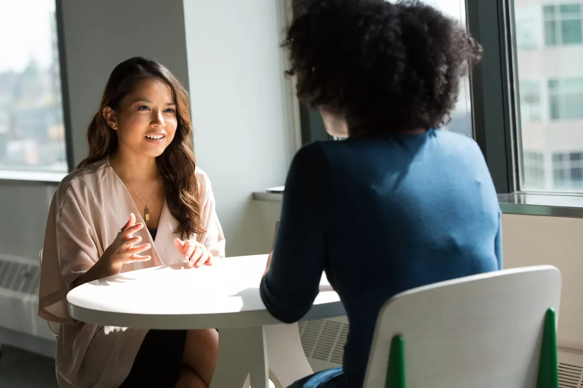 Two colleagues in conversation at a table